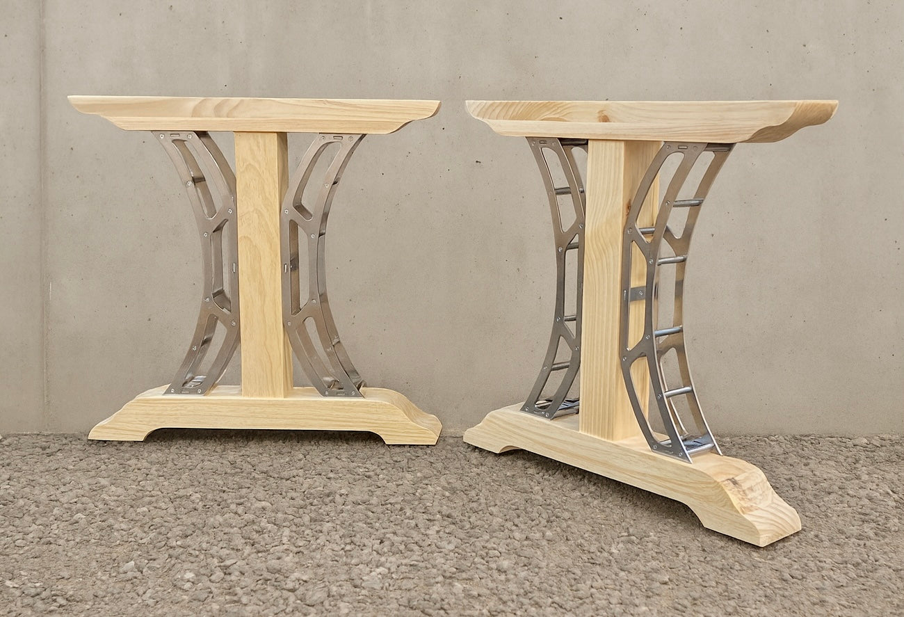 Farmhouse dining table with rustic wood top supported by industrial crescent-shaped steel legs.